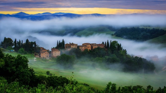 A small village in Tuscany covered by fog in the morning light