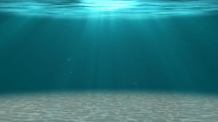 Underwater view of the sea bottom with sunlight filtering through the water