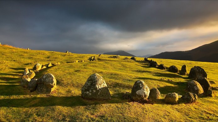 Castlerigg Stone Circle in England with a dark, cloudy sky overhead