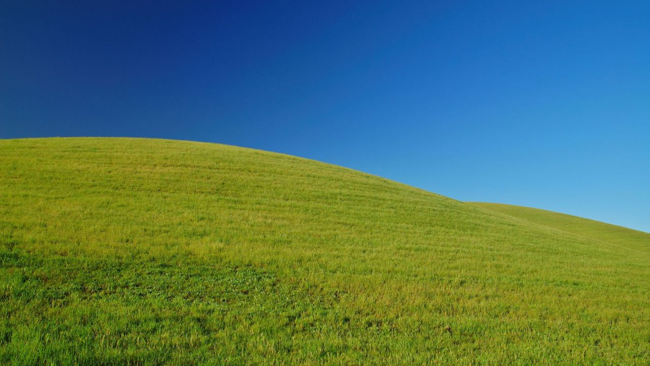 Green hill under a blue sky