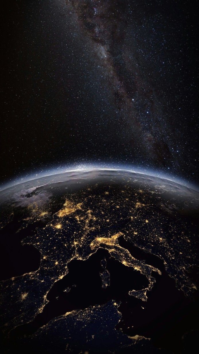Earth at night with city lights and the Milky Way visible