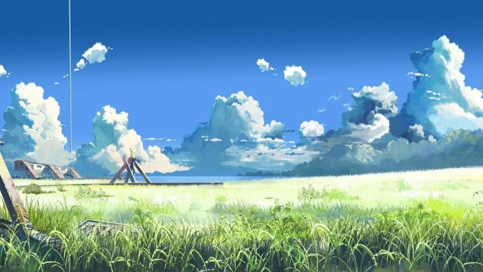 A scenic view of a field under a blue sky with puffy white clouds