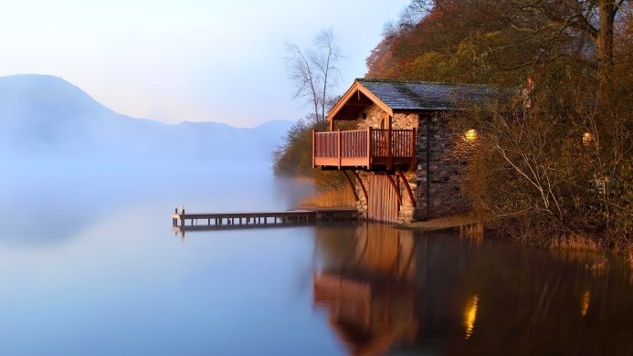 A house on the lake with a dock surrounded by trees