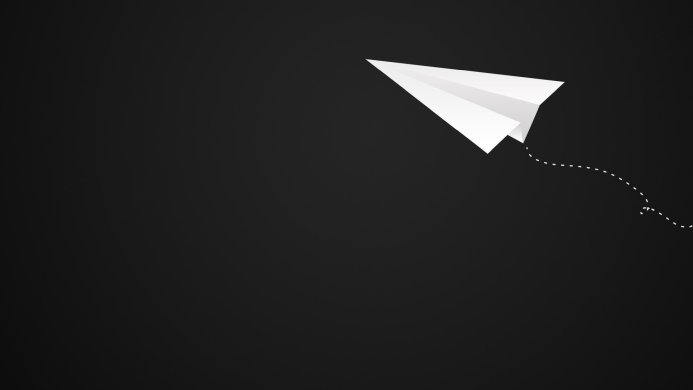 A simple white paper airplane on a black background with a dotted line showing its path