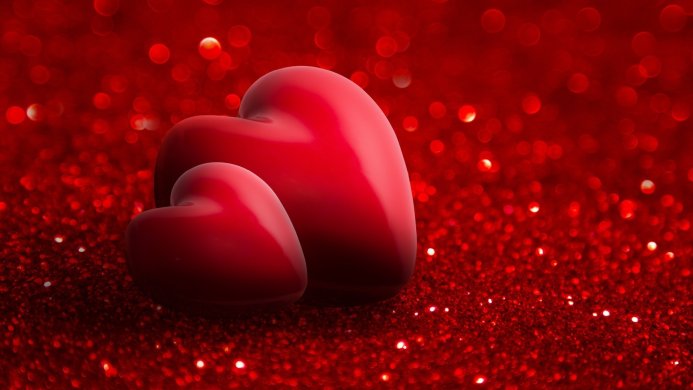 Two red hearts on a red glitter background
