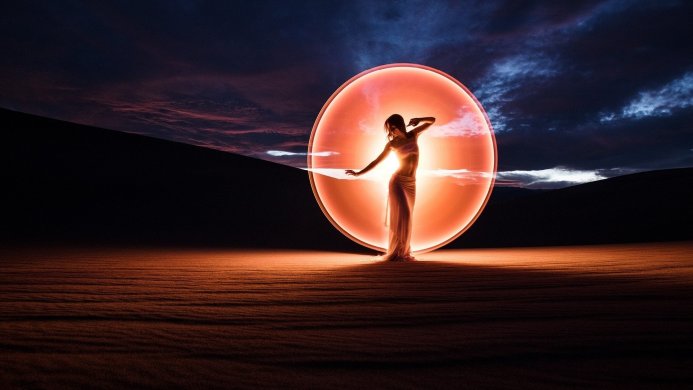 Woman in white dress posing inside a large orange ring with a dark landscape background