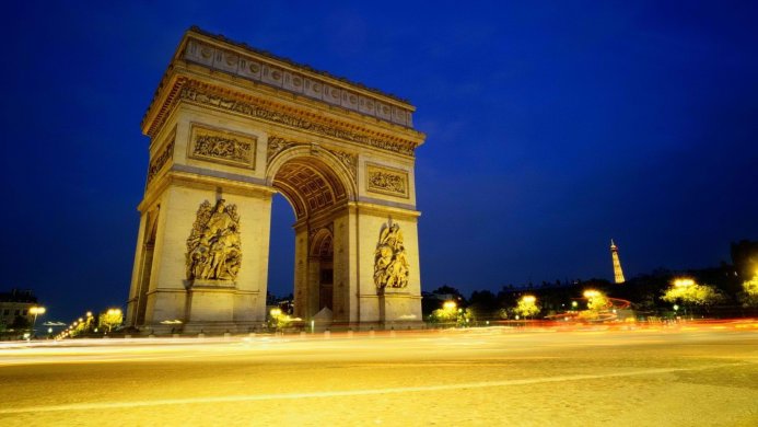 The Arc de Triomphe in Paris at night with light trails from traffic