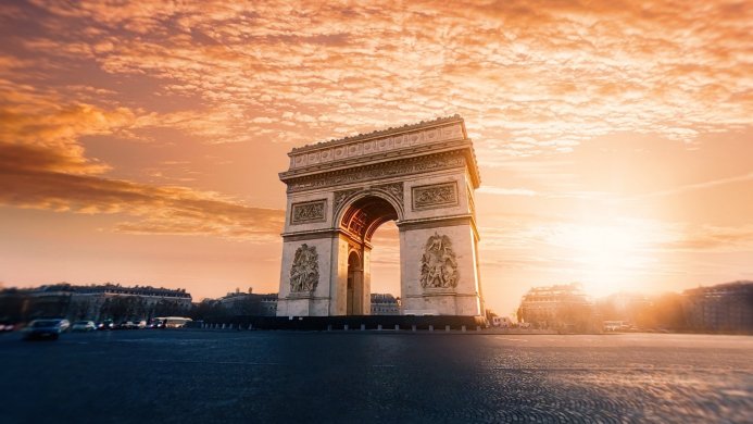 Arc de Triomphe in Paris during sunset with orange sky and clouds