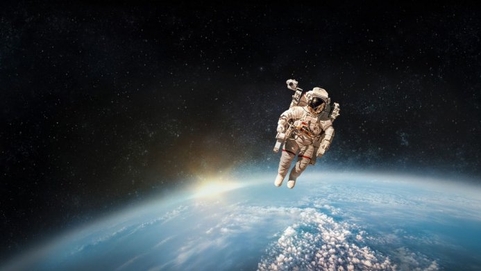 Astronaut in a spacesuit floats above Earth, stars in the background