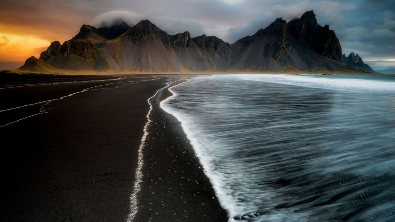 Black sand beach with mountains and sea