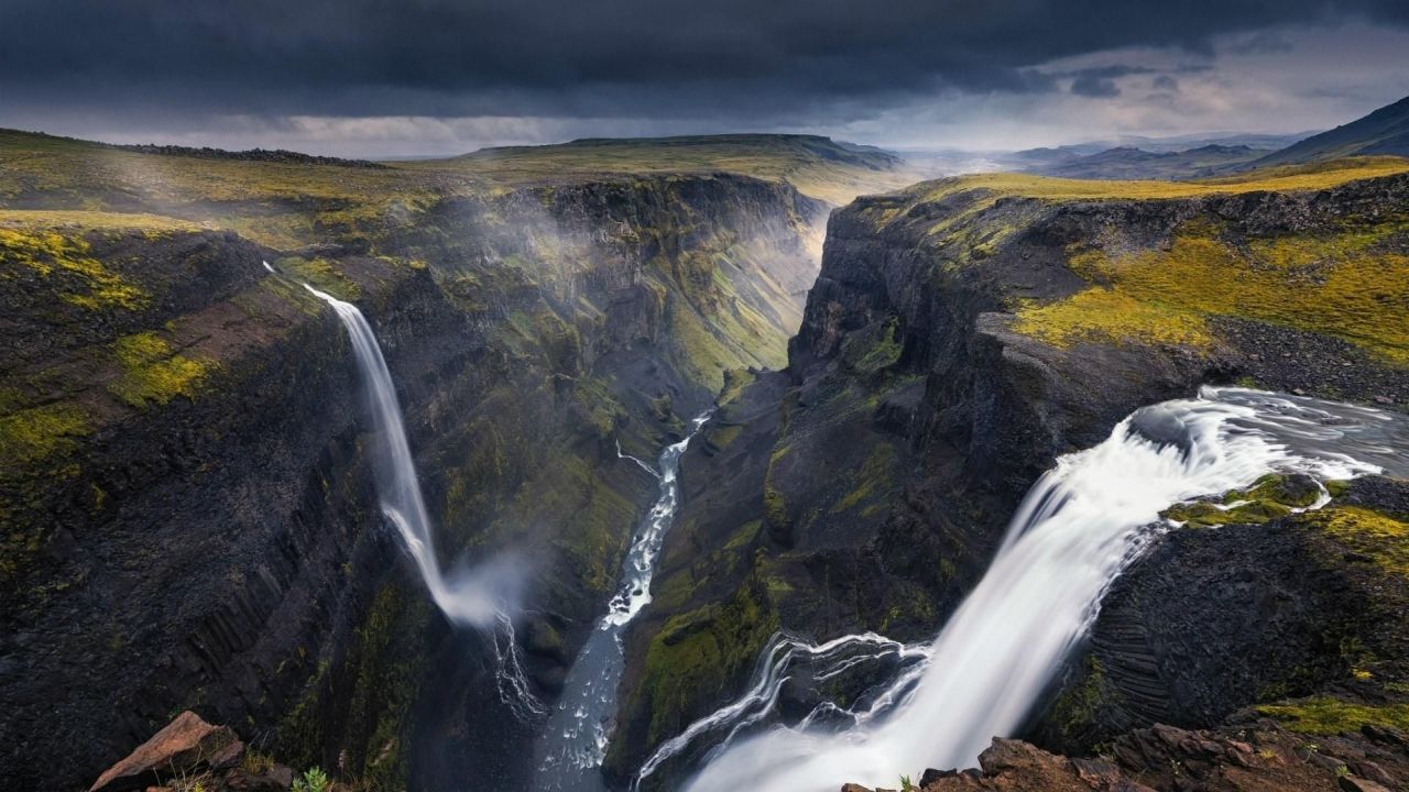 Waterfall in a canyon with a dark sky