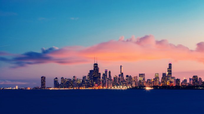 City skyline at dusk with colorful clouds and illuminated skyscrapers