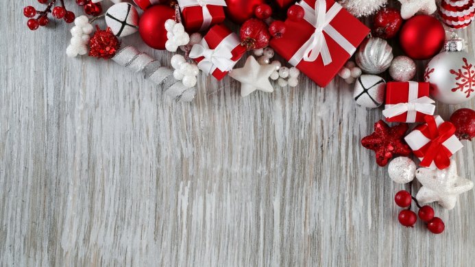 Christmas decorations, gifts, and berries on a wood surface