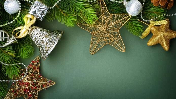 Christmas decorations with stars, bell and fir branches on a green background