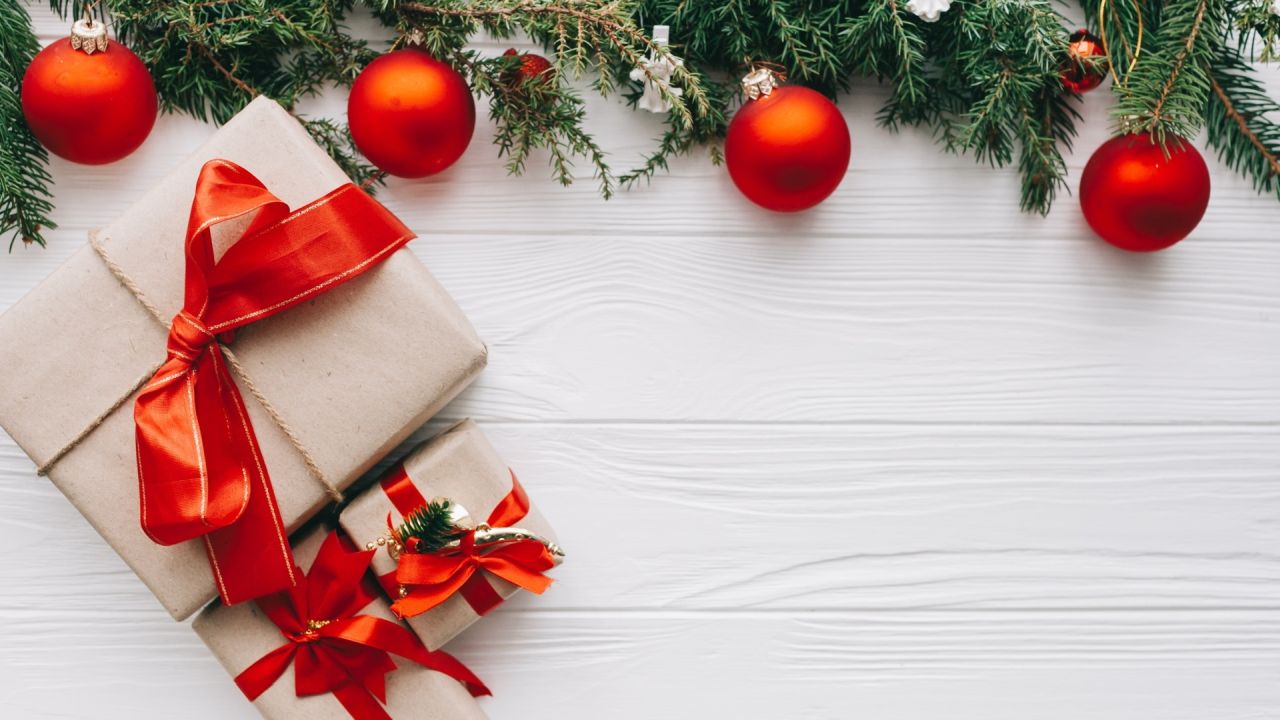 Christmas gifts with red ribbon on white wood