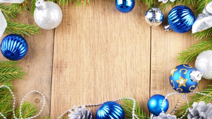 Christmas decorations with blue and silver ornaments, pine cones and fir branches on a wooden surface