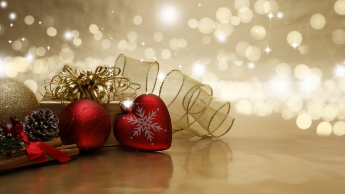 Christmas ornaments, gift box and ribbon on golden background with bokeh lights