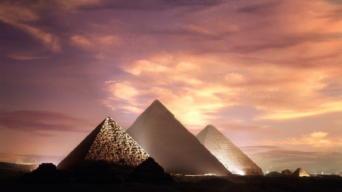 Three ancient pyramids in Egypt during sunset with warm light