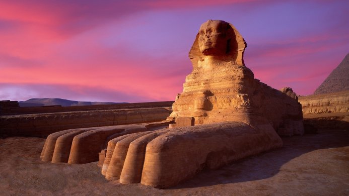 The Great Sphinx of Giza, Egypt, under a vibrant pink and purple sky at dusk