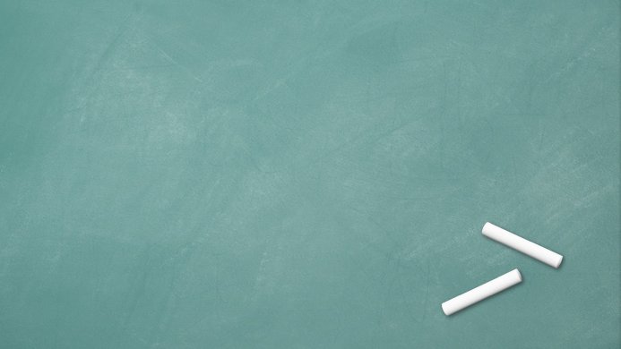 A green chalkboard with two pieces of white chalk in the lower right corner