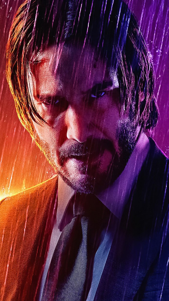 John Wick in a suit standing in the rain
