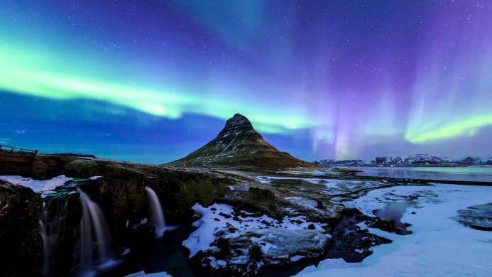 Kirkjufell mountain with aurora borealis and waterfall in Iceland during winter night