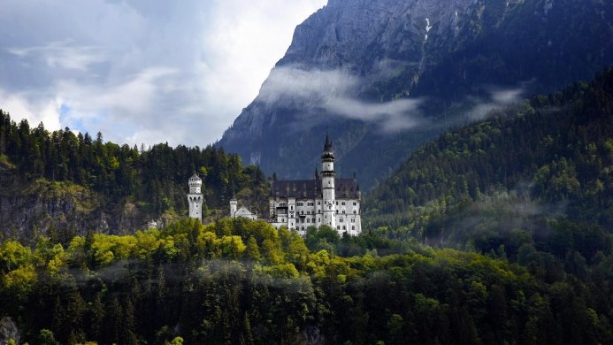 Neuschwanstein Castle nestled in the Bavarian Alps surrounded by a lush green forest