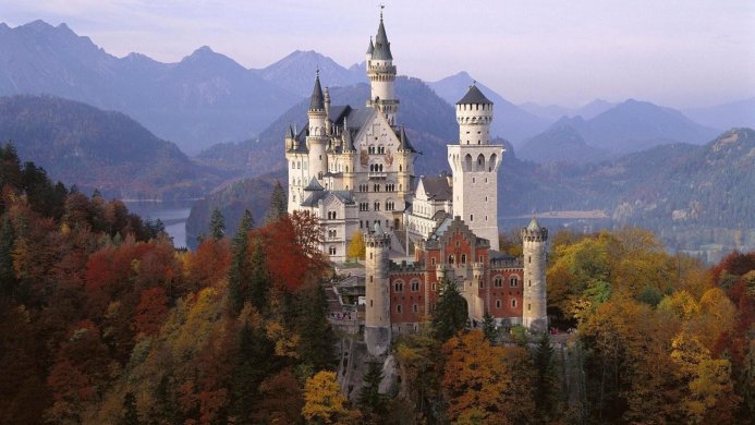 Neuschwanstein Castle in Germany surrounded by autumn trees and mountains