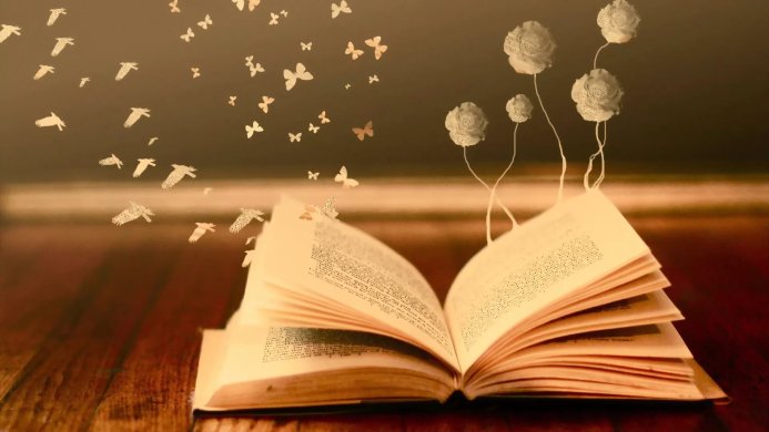 Open book with butterflies and flower-shaped balloons on a wooden table