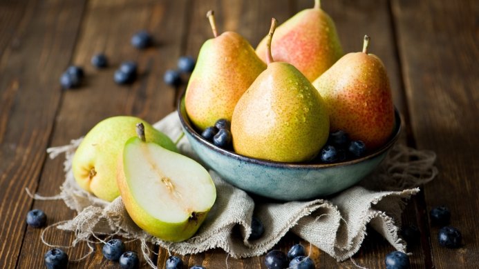 Pears and blueberries in a bowl on a wooden surface