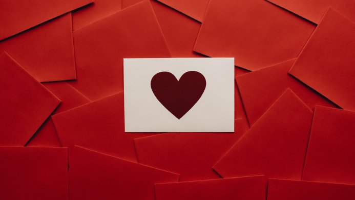 White envelope with a red heart on a background of red envelopes