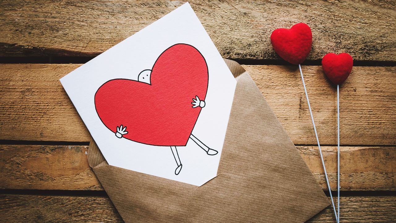 Love card with heart in envelope on wood