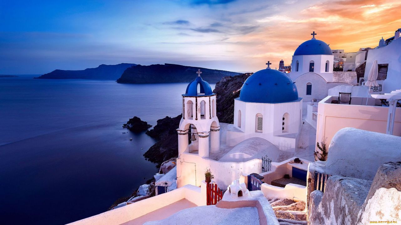 Santorini buildings with blue domes near the sea
