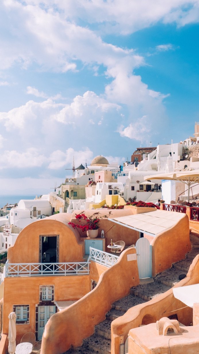 White buildings of Santorini, Greece against a blue sky with clouds