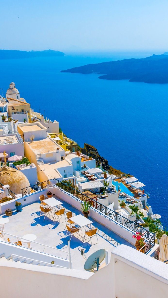 White houses on a cliff overlooking the blue sea in Santorini, Greece