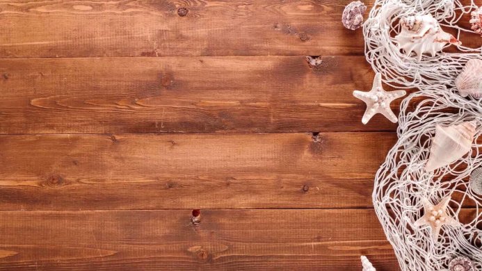 Seashells and starfish in a fishing net on a wooden surface
