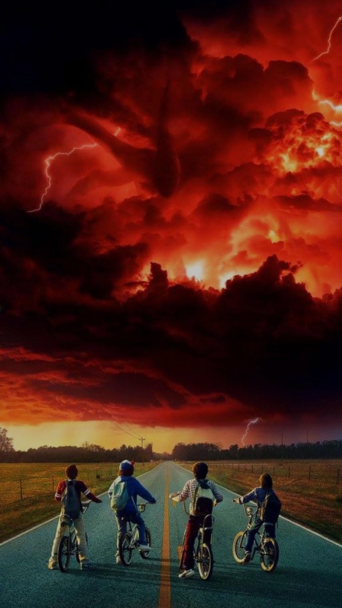 Four children on bikes face a threatening red sky in a scene from Stranger Things
