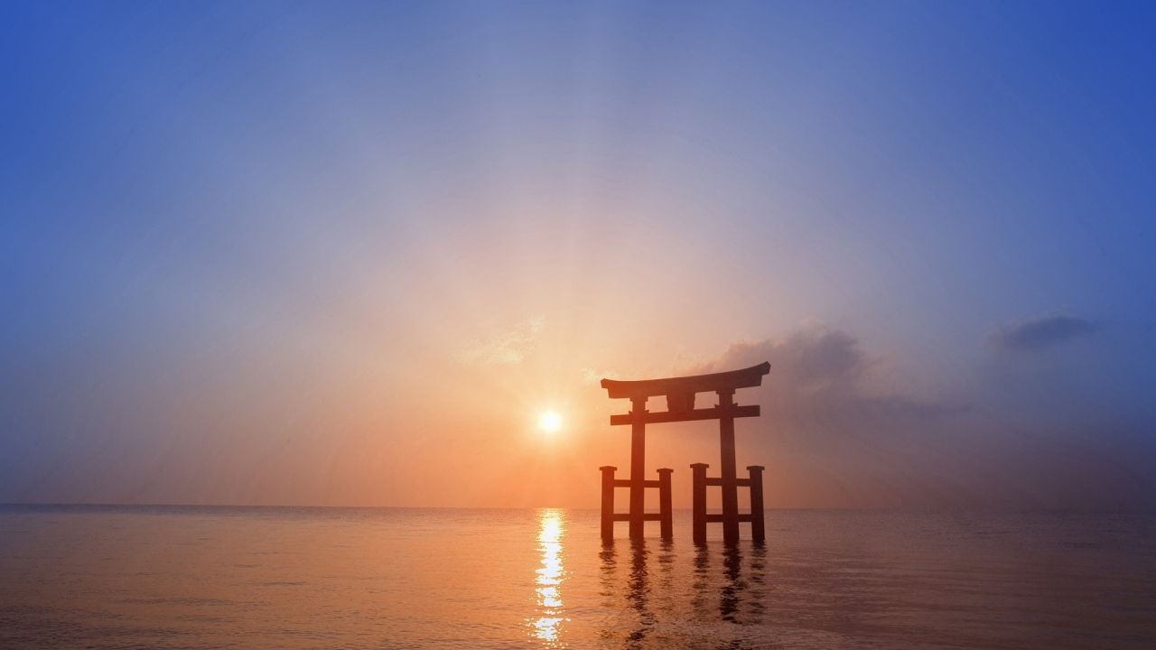 Torii gate at sunrise in the sea