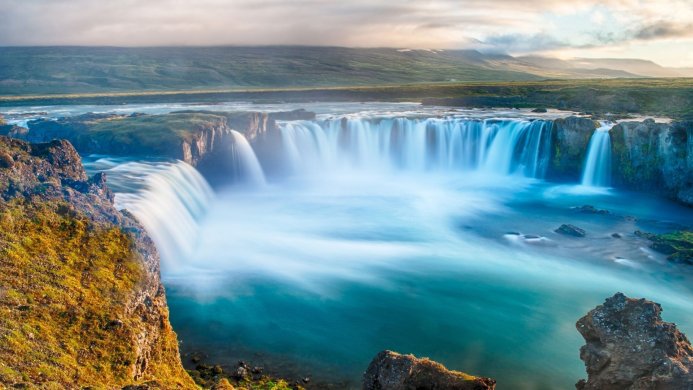 Majestic waterfall cascading over rocks in a serene landscape setting