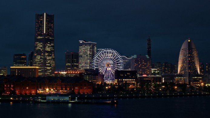Night view of Yokohama city skyline with Ferris wheel illuminated in white