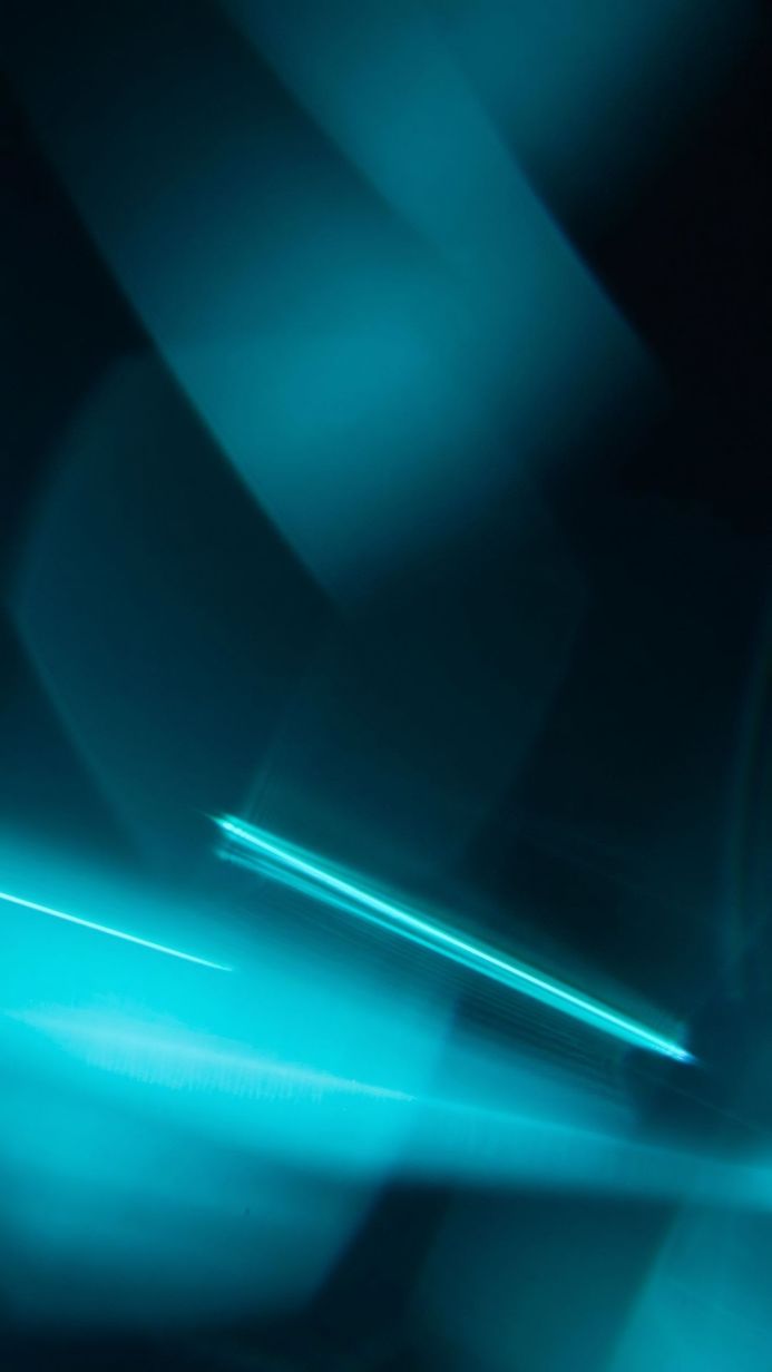 Abstract image of turquoise and blue light streaks on a dark background