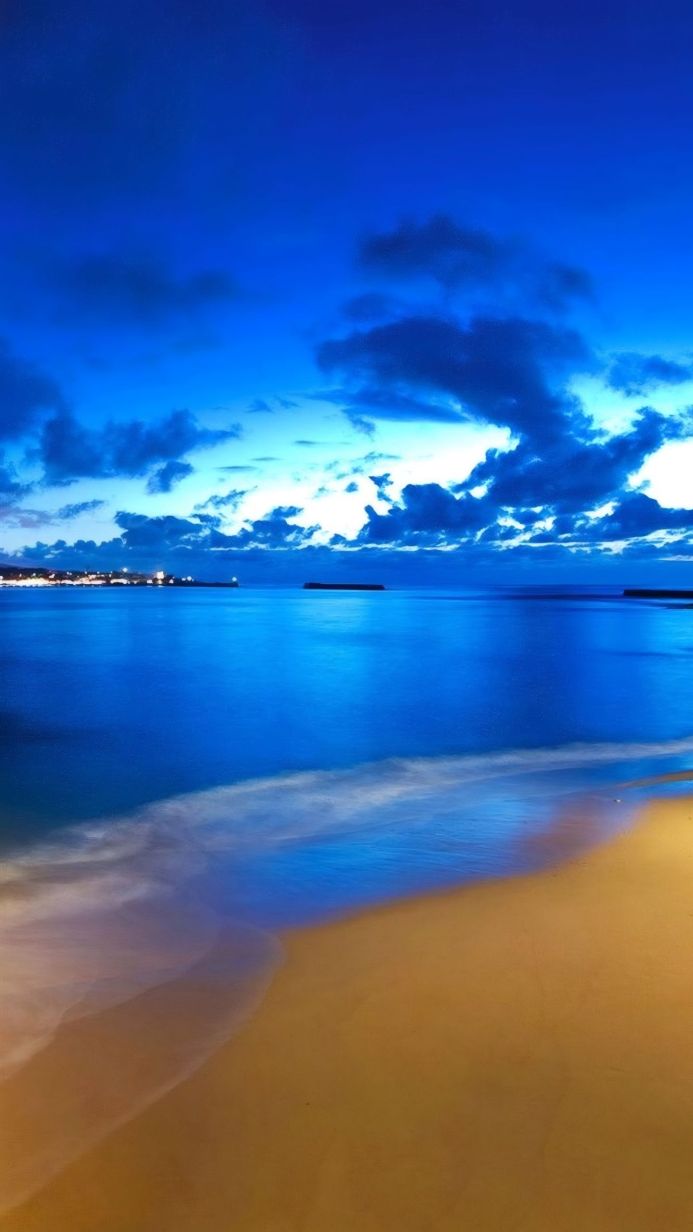 Seascape with blue sky, sea, and sand beach at dusk