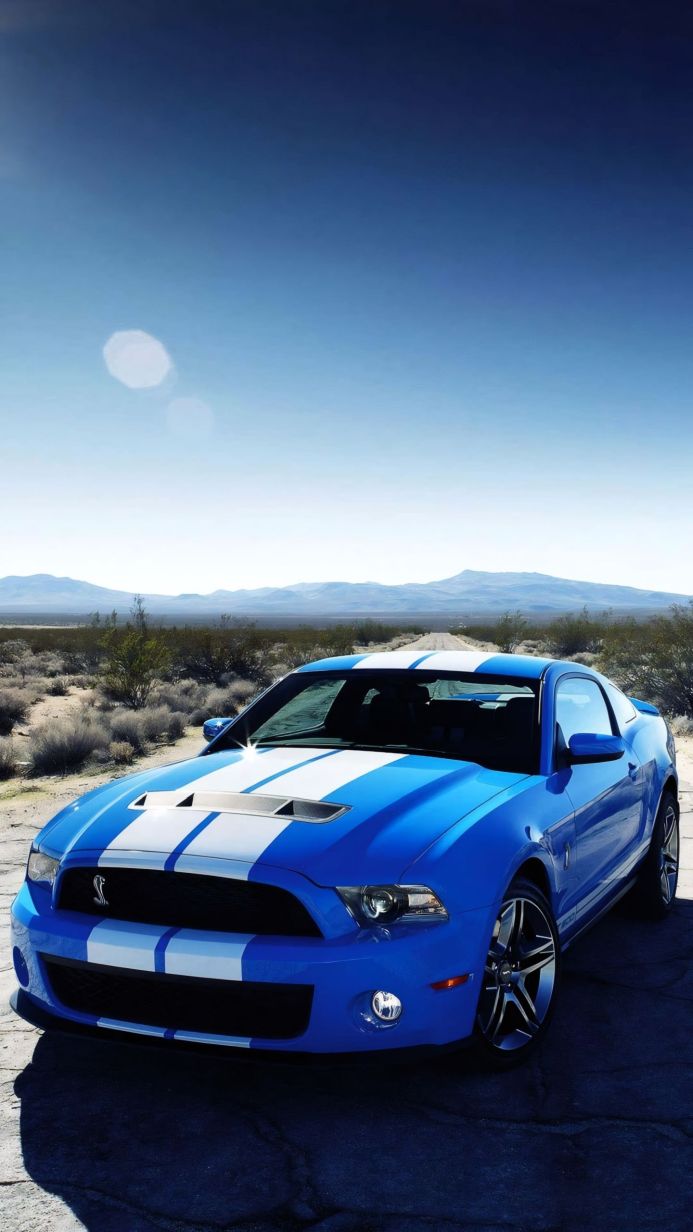 Blue Ford Mustang Shelby GT500 with white stripes in a desert landscape
