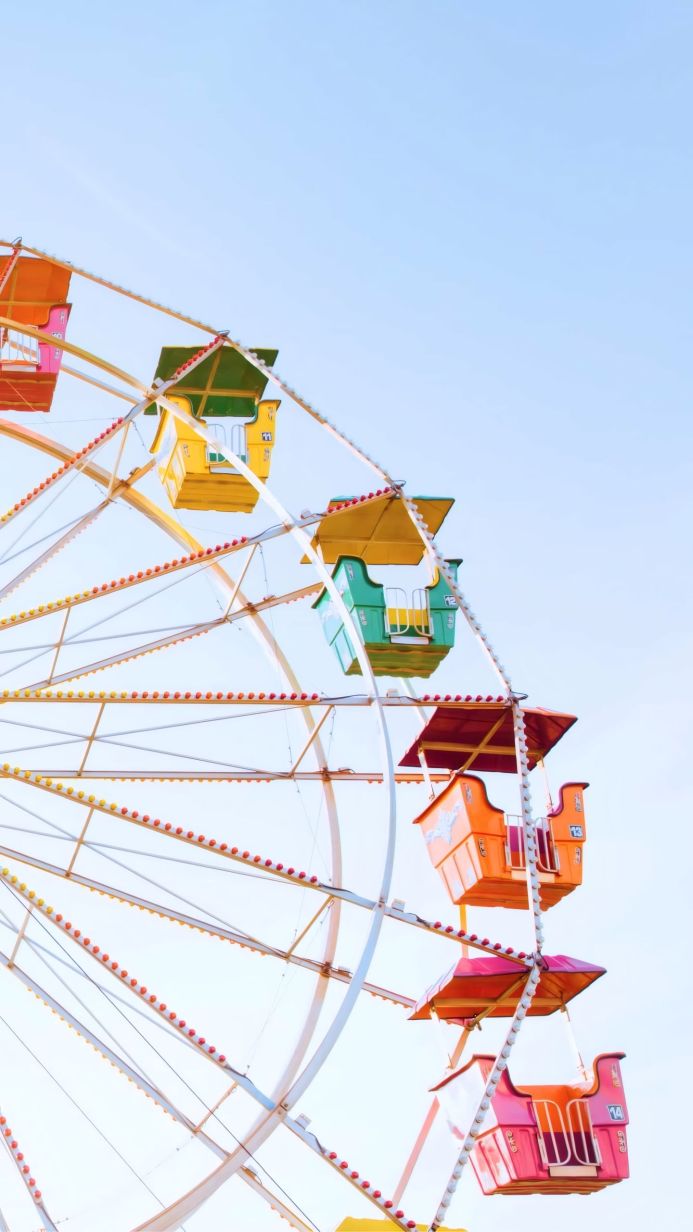 Close up of a colorful Ferris wheel with blue sky background