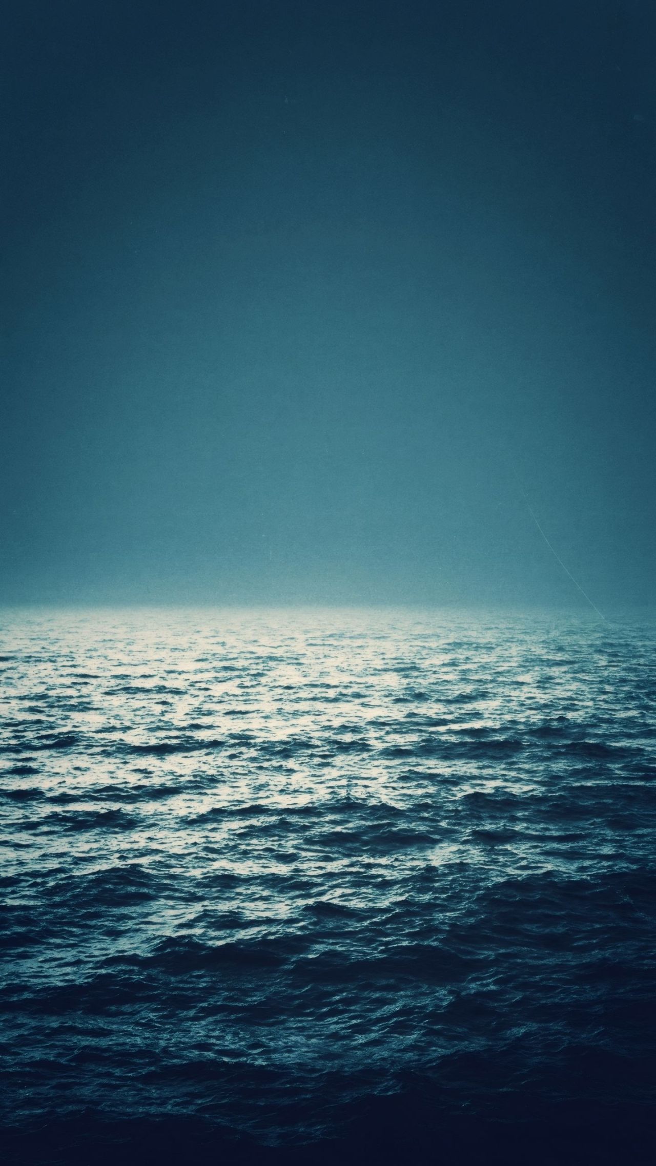 Dark blue ocean waves and hazy sky