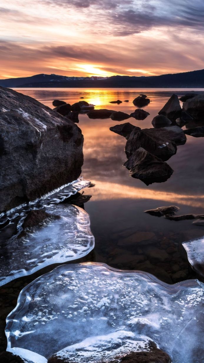 Icy rocks in the lake at sunset