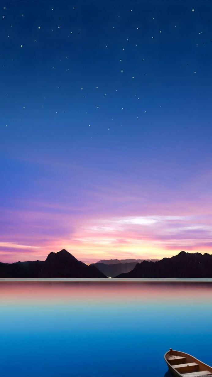A serene lake scene at sunset with mountains and a boat