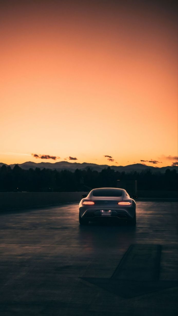 Mercedes-AMG GT at sunset with mountains in the background, gray car