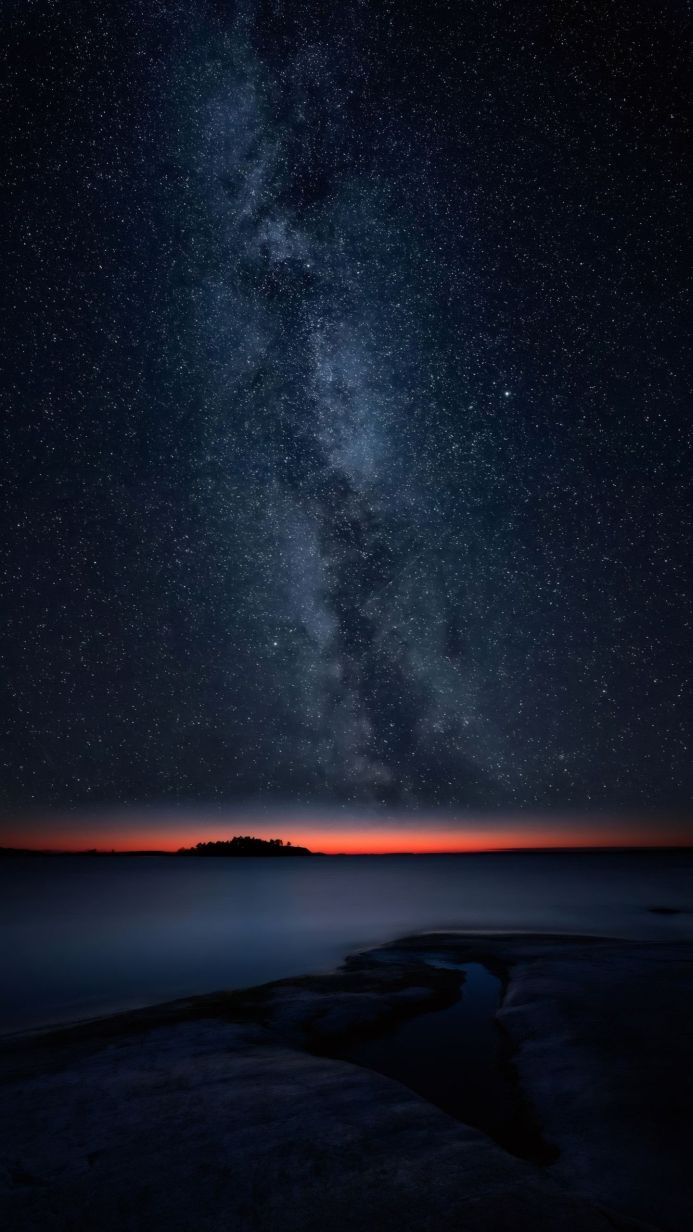 Night sky with the Milky Way over the sea and a small island