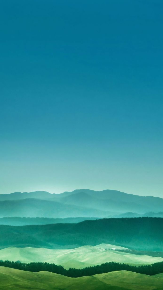 A mountain landscape with green hills under a blue sky